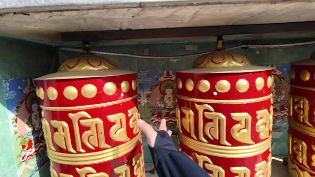 4k video footage of A woman is spinning Nepalese prayer wheels at Annapurna Base Camp (ABC) Trek. Blessing Buddhist writings with nepali characters on the wheel surface