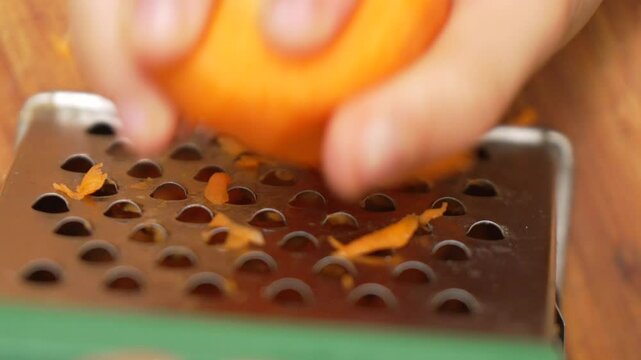 Apricot Zest Grater Kitchen: Hands grating apricot zest on grater for cooking recipe.