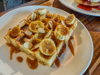 Banana, Almond, And Caramel Waffle On A White Plate
