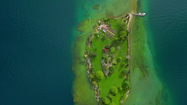 Ascending top down drone footage of the San Biagio island on Lake Garda in Brescia, Lombardy, Italy