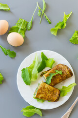 Healthy egg roll with greens on a white plate