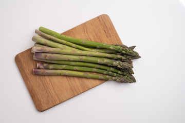 Green asparagus on a light background. Bunch of ripe fresh asparagus. Healthy organic food. Cook at home. Natural vitamins, raw materials for food. Handpicked Bio Asparagus