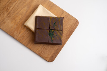 Top view of dark chocolate bar wrapped in foil. Delicious chocolate close-up with nut filling
