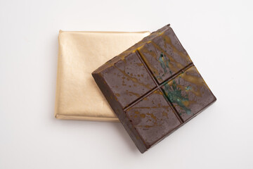 Top view of dark chocolate bar wrapped in foil. Delicious chocolate close-up with nut filling