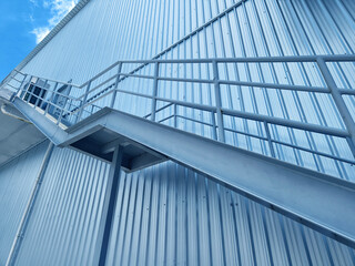 A set of stairs ascending a large blue wall