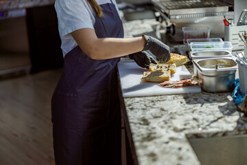 A skilled chef artfully prepares a delicious sandwich in a modern, contemporary kitchen environment