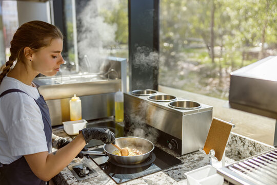 A young chef skillfully cooks in a contemporary kitchen, showcasing culinary expertise and creativity.