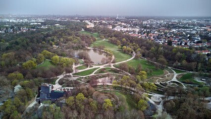 View of Westpark and part of Munich city from above. A cloudy day, a gray horizon. Aerial drone shot. Trees and bushes are still partially leafless. Spring has arrived.