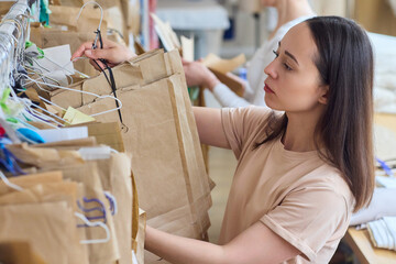 A woman is efficiently organizing the fashion media stock in her creative workspace environment