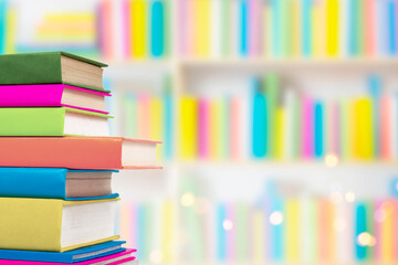 Books in multi-colored covers on an bookshelves. Literature for children. Collection in the library. Textbooks for school college or university