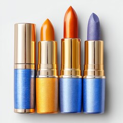 Four lipsticks with gold caps and glittery blue and gold tubes on a white background. Shades include orange, burnt orange, and purple glitter. Close up studio shot.