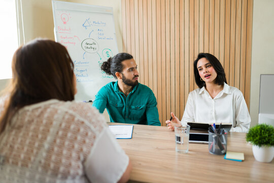 Latin recruiters talking about a job offer to a candidate during an interview