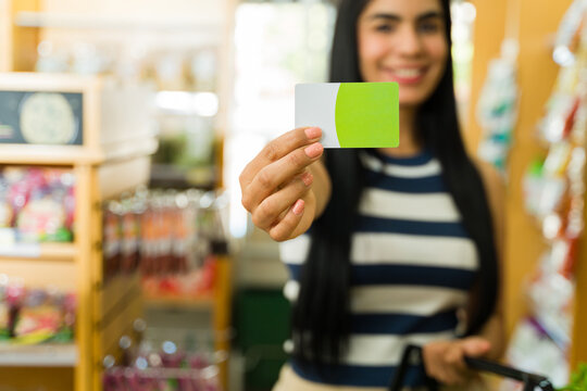 Woman showing loyalty card in supermarket