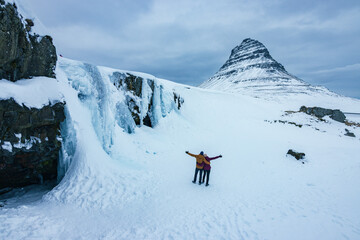 View of Kirkjufell mountain and the frozen kirkjufellsfoss waterfall in Snaefellsnes peninsula...