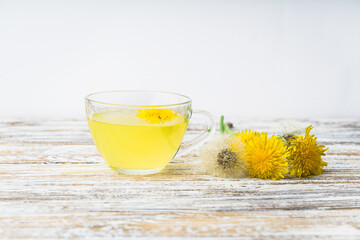 Dandelion tea in a transparent cup. Healthy herbal tea.
