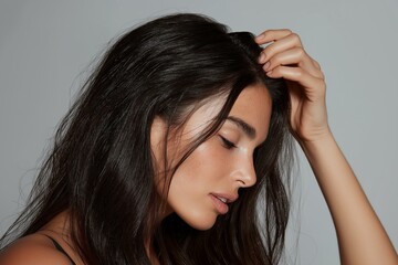 Obraz premium A woman relaxing with a contemplative expression on a neutral background.