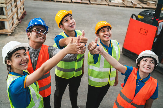 asian warehouse group worker unite hand. employee team showing spirit at cargo shipping workplace join hand to empower. logistic shipping worker with safety helmet and vest empower unite for support