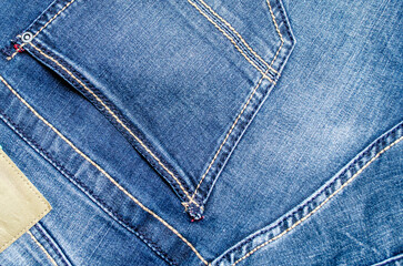 Fototapeta premium Close-up of blue denim jeans pocket in daylight for fashion and textile design