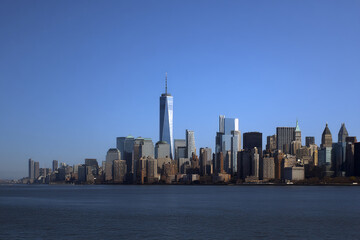 Naklejka premium Panoramic view of city skyline against clear blue sky, showcasing modern architecture and urban landscape, representing urban development and progress