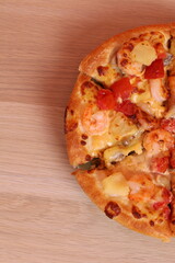 Hand holding Hawaiian pizza