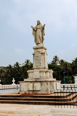 Goa, India - February 20, 2025: The statue of Jesus facing the Se Cathedral and Church of St. Francis of Assisi, a 17th Century Catholic Church in Goa, India
