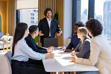 Caucasian man sale manager is presenting new project to colleagues in executive meeting for next...