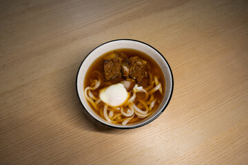 A bowl of meat udon with egg.