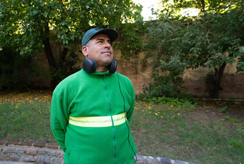 A man wearing a green sweatshirt and headphones