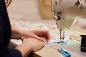 A Focused Seamstress Diligently Working with a Sewing Machine in Her Creative Workspace