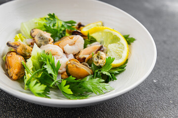 Salad seafood shrimp, mussels, squid, rapawn, prawn, green mixed leaf dish fresh food background on the table rustic food top view copy space 