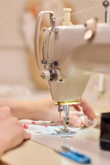 A Focused Seamstress Diligently Working with a Sewing Machine in Her Creative Workspace