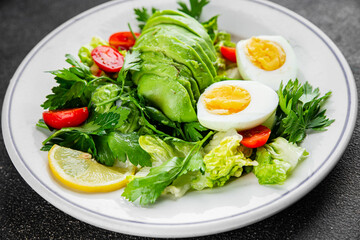 Avocado salad, boiled egg, tomato, green leaf lettuce, vegetable dish fresh delicious gourmet food background on the table rustic food top view copy space 