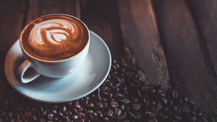 Top view of Latte arts coffe. White cup of hot coffee on wooden table. Cafe with barista art concept.	

