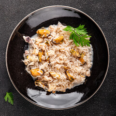 Rice seafood risotto mussel, shrimp, prawn, rapan, squid dish fresh gourmet food background on the table rustic food top view copy space