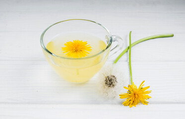 Dandelion tea in a transparent cup. Healthy herbal tea.