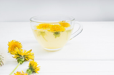 Dandelion tea in a transparent cup. Healthy herbal tea.