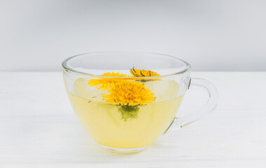 Dandelion tea in a transparent cup. Healthy herbal tea.
