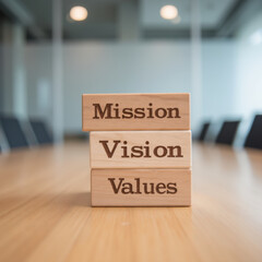 Mission, Vision, Values blocks on wooden table in modern office setting, symbolizing corporate culture and strategic planning