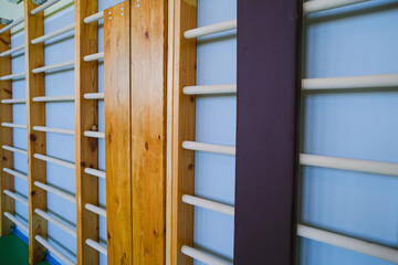 Wooden gymnastics ladder mounted in gymnasium hall