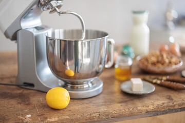 In a cozy rustic kitchen, a premium stand mixer kneads dough for homemade Cozonac, featuring...