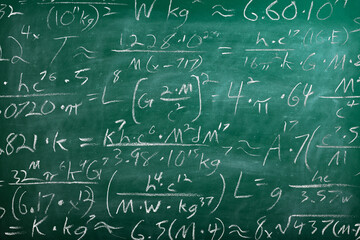 School chalk board is painted with different formulas and signs from the school curriculum. A green...