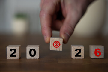 2026 Happy New Year. Wooden cube block change from 2025 to 2026 on blue. Concept 2026 New Year...
