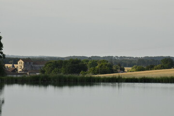 Reflet du ciel bleu dans le grand étang de retenue près du bourg de Champagne au Périgord Vert 