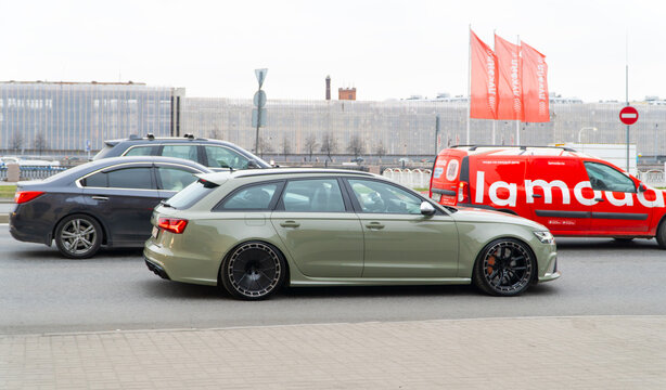 A green Audi RS6 touring cars on road street, luxury car exterior. The modern exterior of a premium Germany car Audi RS6 Avant (C7) pistachio color. WAG group car. 
