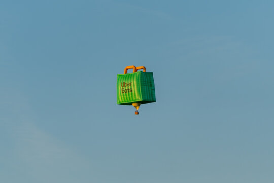 Germany Berlin May 1, 2025. A balloon in the shape of a bag with the word uber Eats written on it hovers in the air against a blue sky. Advertising balloon in the sky.