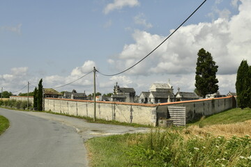 Cimetière typique entouré d'un mur d'enceinte au bourg de Champagne au Périgord Vert 