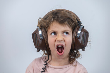 child making faces wearing vintage headphones