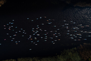 An aerial shot captures a vibrant scene of numerous SUP paddleboarders enjoying a sunny day on a...