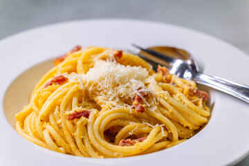 close up of spaghetti carbonara in white bowl