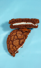 Two Chocolate Cookie Sandwiches on Blue Background